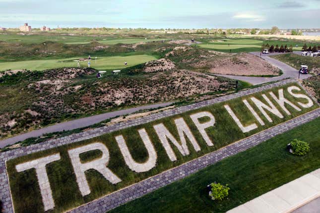 FILE — Patrons play the links as a giant branding sign is displayed with flagstones at Trump Golf Links, at Ferry Point in the Bronx borough of New York, May 4, 2021. The Trump Organization has sold its right to operate a public golf course in the Bronx, city officials confirmed, Friday, Sept. 8, 2023, offloading control of the city-owned property to a company that is seeking to build a casino in New York City. (AP Photo/John Minchillo, File)