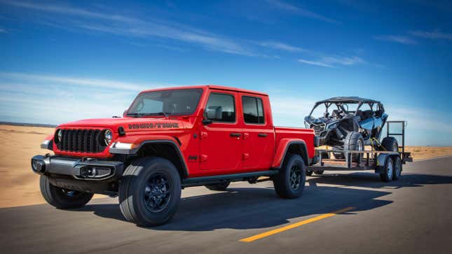 A red gladiator High Tide edition driving near a beach towing a side-by-side