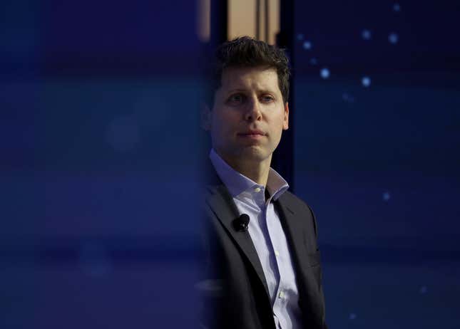 Sam Altman staring in one direction wearing a blue button down and black suit jacket