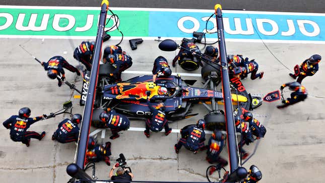 A photo of a Red Bull F1 car making a pit stop during a race. 