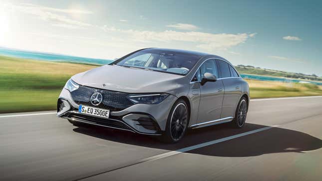 A grey Mercedes EQE driving down a road