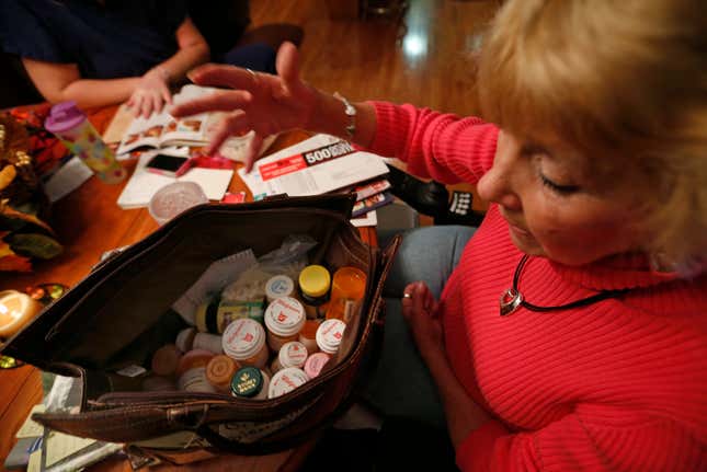 A woman with a small bag full of various prescription drugs