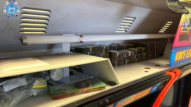 Cash sits stacked above an arcade cabinet. 