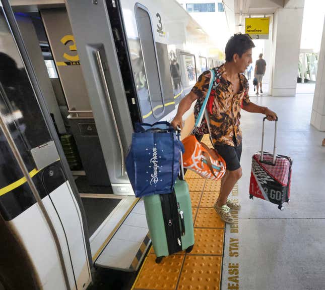 A Disney fan arrives in Miami on the first Brightline train from Orlando on the debut of service from Orlando International Airport, early Friday, Sept. 22, 2023. The high-speed Orlando-Miami route marks first new privately-owned inter-city passenger service to roll out in the U.S. in 100 years. (Joe Burbank /Orlando Sentinel via AP)