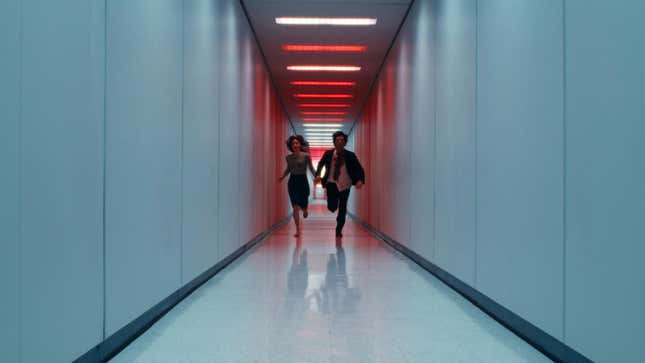 Helly and Mark run down a hallway.