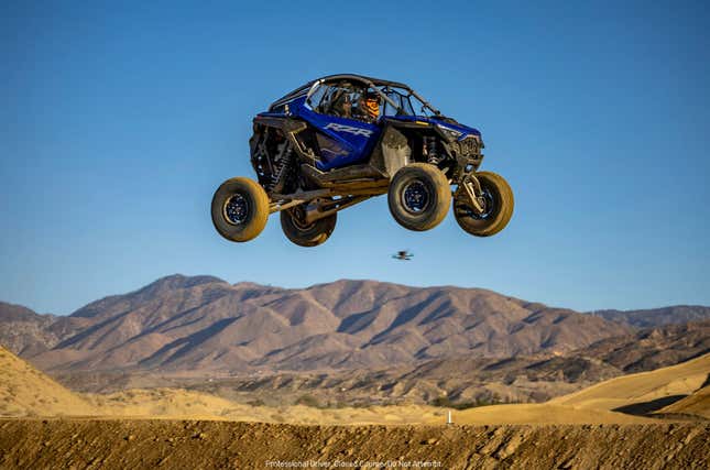 Blue UTV sails through the air in the California desert.