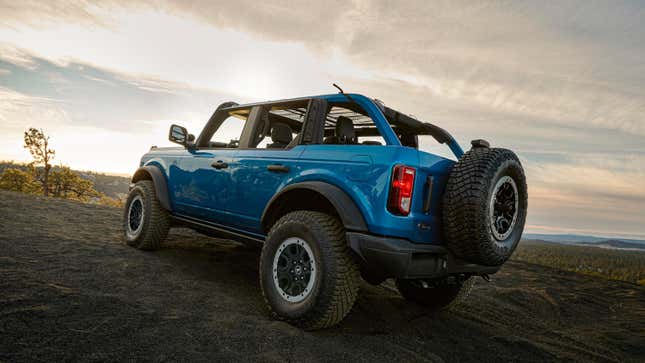 Un Bronco azul sin techo estacionado en la arena