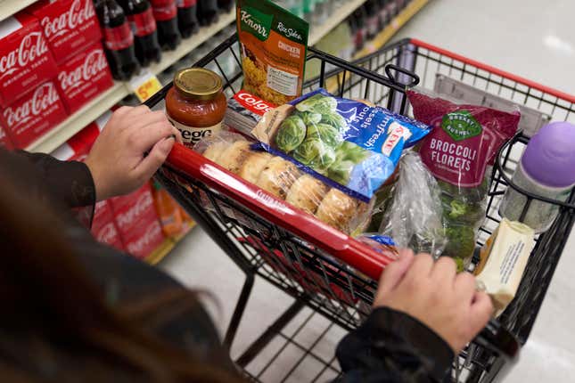 File - A food shopper pushes a cart of groceries at a supermarket in Bellflower, Calif., on Monday, Feb. 13, 2023. Preparing for a midnight toast and more year-end festivities may require a run or two to the store — but you’ll want to prepare for some limited business hours. (AP Photo/Allison Dinner, File)