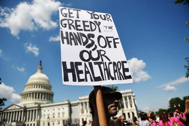  A protester holds a sign during a demonstration of Democratic Senators to oppose the repeal of the Affordable Care Act and its replacement on Capitol Hill on June 21, 2017, in Washington, DC.