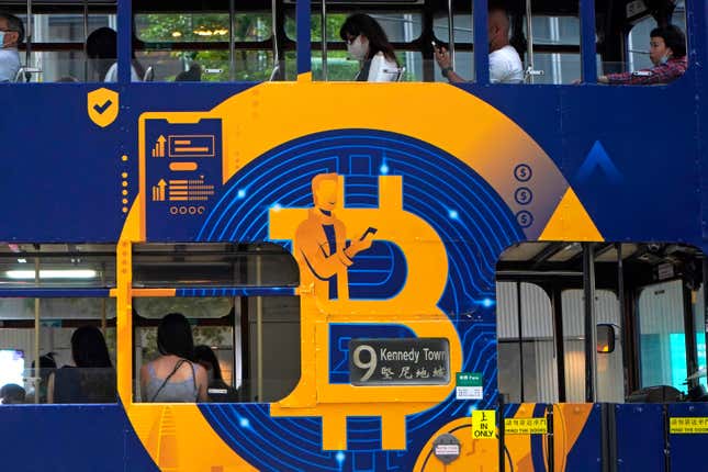 FILE - An advertisement for the cryptocurrency Bitcoin displayed on a tram, May 12, 2021, in Hong Kong. Sometime in the next few days or even hours, the “miners” who chisel bitcoins out of complex mathematics are going to take a 50% pay cut — effectively slicing new emissions of the world’s largest cryptocurrency in an event called bitcoin halving. (AP Photo/Kin Cheung, File)