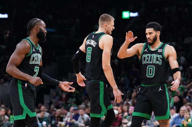 Nov 13, 2023; Boston, Massachusetts, USA; Boston Celtics forward Jayson Tatum (0), center Kristaps Porzingis (8) and guard Jaylen Brown (7) react after a play against th eNew York Knicks in the second quarter at TD Garden.