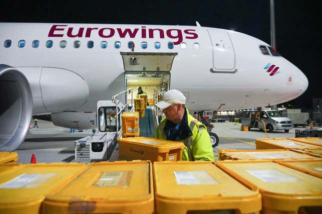 WISAG employees load a Eurowings Airbus A320-214 bound for Stuttgart with plastic boxes full of mail, at Berlin Brandenburg Airport, in Schönefeld, Germany, Thursday, March 28, 2024. Germany&#39;s main national postal carrier on Thursday put an end to domestic flights to transport letters, stopping the practice after nearly 63 years in a move that will allow it to improve its climate footprint and reflects the declining significance of letter mail. Deutsche Post said the last planes carrying letters between northern and southern Germany, operated by Lufthansa unit Eurowings and Tui Fly, flew overnight on the Stuttgart-Berlin, Hannover-Munich and Hannover-Stuttgart routes. (Soeren Stache/dpa via AP)