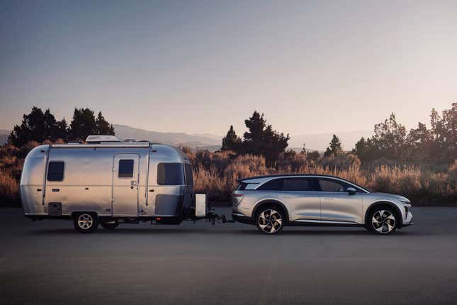 Lucid Gravity electric SUV in silver towing a camper