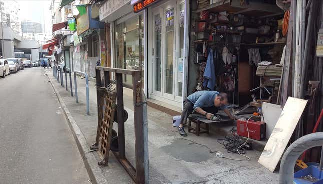 A man cutting some sheet metal with an angle grinder