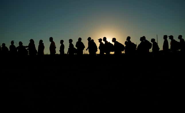 FILE - Migrants who crossed the Rio Grande and entered the U.S. from Mexico are lined up for processing by U.S. Customs and Border Protection, Sept. 23, 2023, in Eagle Pass, Texas. As the number of migrants coming to the U.S.&#39;s southern border is climbing, the Biden administration aims to admit more refugees from Latin America and the Caribbean over the next year. The White House Friday, Sept. 29, released the targets for how many refugees it aims to admit over the next fiscal year starting October 1 and from what regions of the world. (AP Photo/Eric Gay, File)