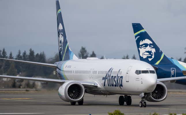 Alaska Airlines plane facing the camera, the tail of another plane can be seen behind the plane