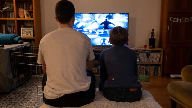 Two people play a videogame together in their family living room.