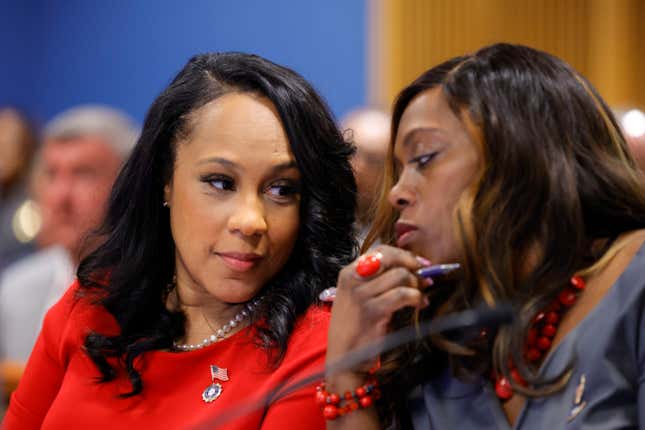 ATLANTA, GA - MARCH 01: Fulton County District Attorney Fani Willis, left and prosecutor Daysha Young, right, speak to each other during a hearing in the case of the State of Georgia v. Donald John Trump at the Fulton County Courthouse on March 1, 2024, in Atlanta, Georgia. 