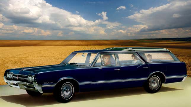 A photo of a family sat in an old Oldsmobile Vista Cruiser wagon. 