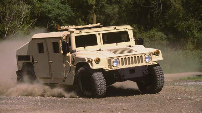 A military Hummer driving through dust 