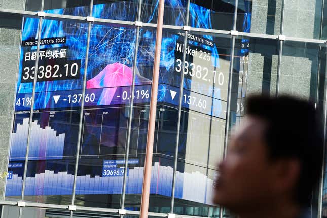 A person walks in front of an electronic stock board showing Japan&#39;s Nikkei 225 index at a securities firm Thursday, Nov. 16, 2023, in Tokyo. (AP Photo/Eugene Hoshiko)