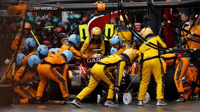 A photo of mechanics working on a Mclaren F1 car. 