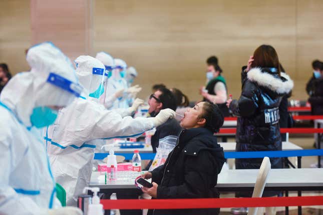 A medical worker takes swab samples during a mandatory covid-19 test on workers of service industries from the Wulin business area in Hangzhou city in east China’s Zhejiang province Wednesday, Dec. 15, 2021. 