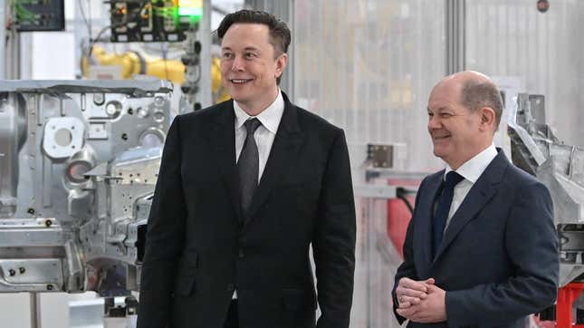 Tesla CEO Elon Musk (L) and German Chancellor Olaf Scholz (R) smile as they attend the start of the production at Tesla’s “Gigafactory” on March 22, 2022 in Gruenheide, southeast of Berlin. 