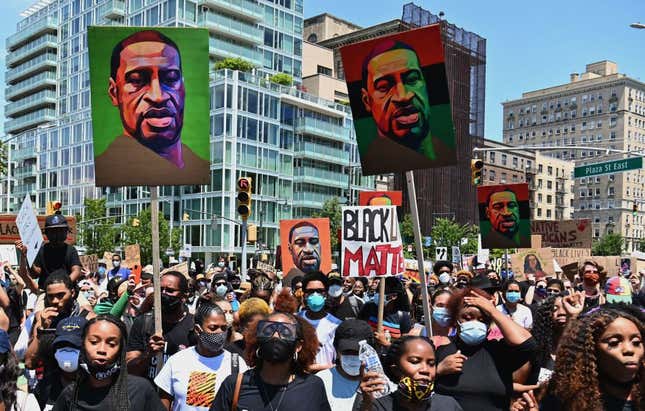 Protestors hold pictures of George Floyd as they march during a Juneteenth rally at Grand Army Plaza on June 19, 2020 in the Brooklyn Borough of New York City. 