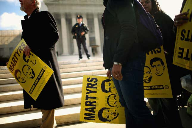 Holding signs with images of murdered Mississippi civil rights workers James Earl Chaney, Andrew Goodman, and Michael “Mickey” Schwerner, demonstrators rally in front of the U.S. Supreme Court February 27, 2013 in Washington, DC. Leaders from Congress joined civil rights icons to rally as the court prepared to hear oral arguments in Shelby County v. Holder, a legal challenge to Section 5 of the Voting Rights Act. 