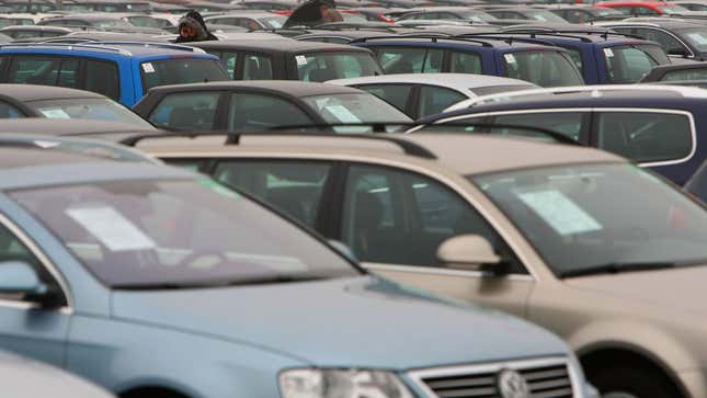 A photo of a parking lot full of cars for sale. 