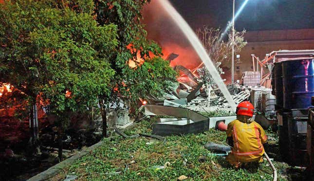 In this image provided by the Pingtung County Government, a firefighter tries to extinguish a fire at a factory of golf ball manufacturer Launch Technologies Co. in the southern county of Pingtung in Taiwan on Friday, Sept. 22, 2023. The factory fire has left multiple people killed, and the victims include several firefighters, according to Taiwanese media reports. (Pingtung County Government via AP)