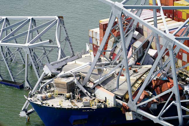 In this aerial image released by the Maryland National Guard, the cargo ship Dali is stuck under part of the structure of the Francis Scott Key Bridge after the ship hit the bridge, Tuesday, March 26, 2024, in Baltimore. (Maryland National Guard via AP)