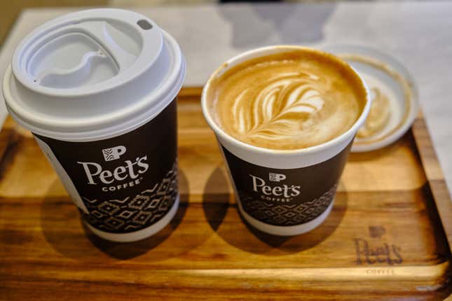 Two cups of coffee on a table in a Peet’s Coffee store.