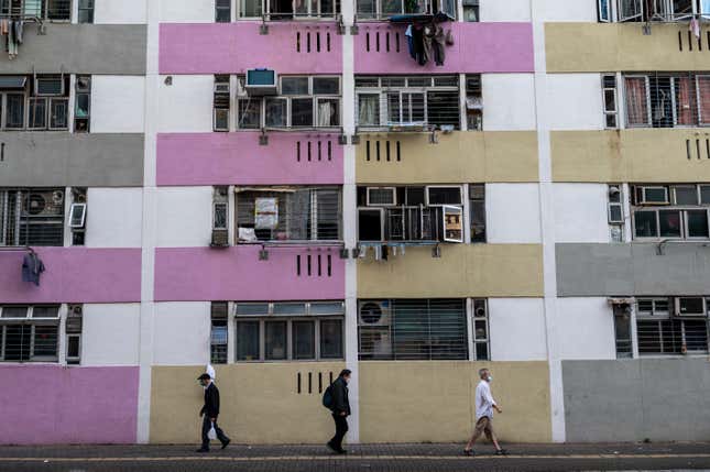 FILE - People walk past public housing buildings in Hong Kong, Wednesday, Oct. 19, 2022. Hong Kong&#39;s leader has cut taxes for some homebuyers and stock traders to boost markets as the city seeks to maintain its reputation as a global financial hub. (AP Photo/Vernon Yuen, File)