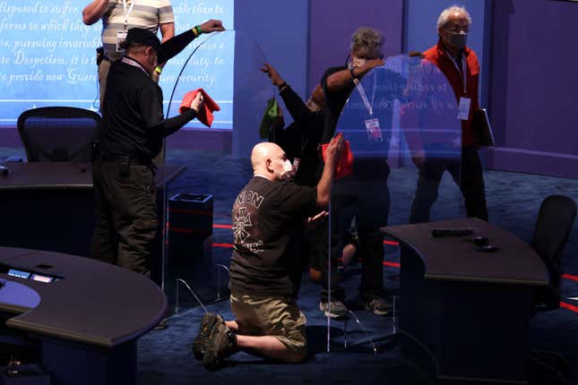 Workers install plexiglass barriers on the stage ahead of the vice presidential debate in Kingsbury Hall of the University of Utah October 6, 2020 in Salt Lake City, Utah. U.S. Vice President Mike Pence and Democratic vice presidential nominee Sen. Kamala Harris (D-CA) will face off in the 2020 vice presidential debate on Wednesday evening.