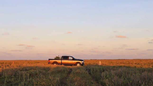 A photo of a truck parked on a plot of land. 