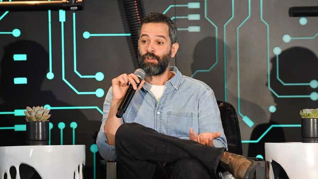 Neil Druckman talks into a microphone at an event. 