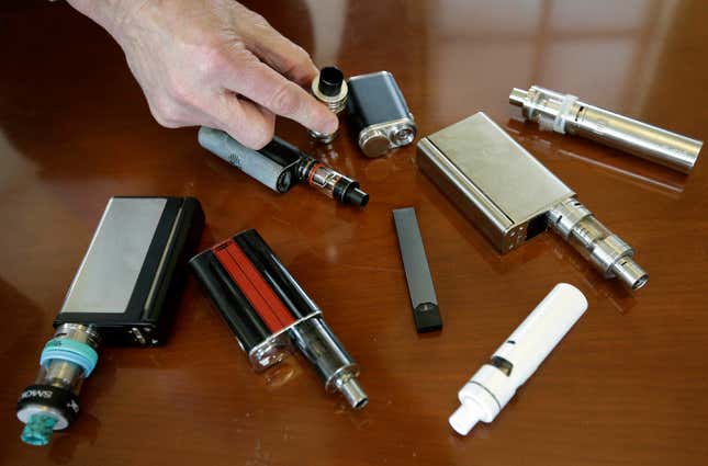 FILE - In this April 10, 2018 file photo, a high school principal displays vaping devices that were confiscated from students in such places as restrooms or hallways at the school in Massachusetts. Schools around the country are installing sensors and cameras to crack down on student vaping, and handing out harsh punishments for many who are caught. Schools have invested millions of dollars in the surveillance technology, including federal COVID-19 emergency relief money meant to help schools through the pandemic. (AP Photo/Steven Senne)