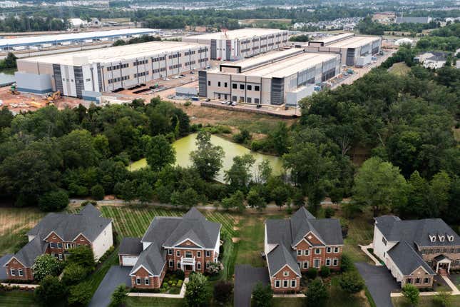 aerial view of amazon web services data center located behind four single-family homes