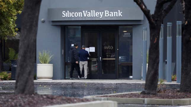 A man puts a sign on the door of Silicon Valley Bank in Santa Clara, California