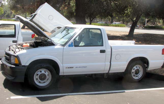 Ein weißer Chevy S10 ev , der mit offener Motorhaube auf einem Parkplatz geparkt ist 