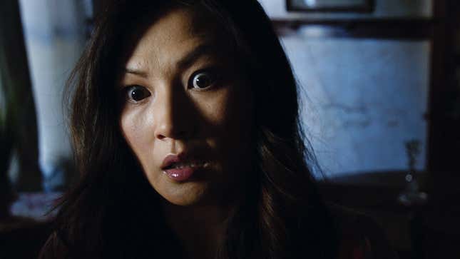 A woman stares straight ahead with wide eyes and a terrified look on her face.