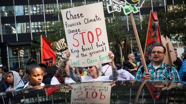 Environmental activists protest outside Chase Bank, calling for banks to divest in fossil fuels and invest in renewable energy on October 14, 2015 in New York City. While the protest was billed as an environmental demonstration, activists also protested against racial discrimination, housing issues, controversial techniques used in the financial industry and the prison industrial complex.