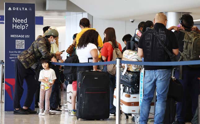 Les voyageurs font la queue à l’étage d’enregistrement du terminal de Delta Air Lines à l’aéroport international de Los Angeles