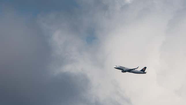 A plane flies near a cloud