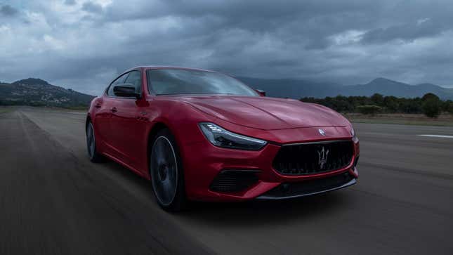 A photo of a red Maserati Ghibli sedan on a track. 