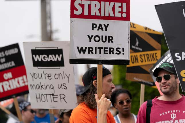 Demonstrators hold signs during a rally outside the Paramount Pictures Studio in Los Angeles, Thursday, Sept. 21, 2023. Negotiations between striking screenwriters and Hollywood studios have resumed and will continue Thursday, the latest attempt to bring an end to pickets that have brought film and television productions to a halt. (AP Photo/Jae C. Hong)