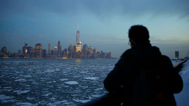 Un hombre observa témpanos de hielo, el horizonte del Bajo Manhattan de Nueva York y el One World Trade Center en un parque a lo largo del río Hudson en  Hoboken, Nueva Jersey