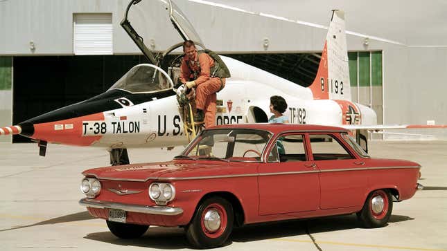 A photo of a fighter pilot inspecting a Chevrolet sedan. 